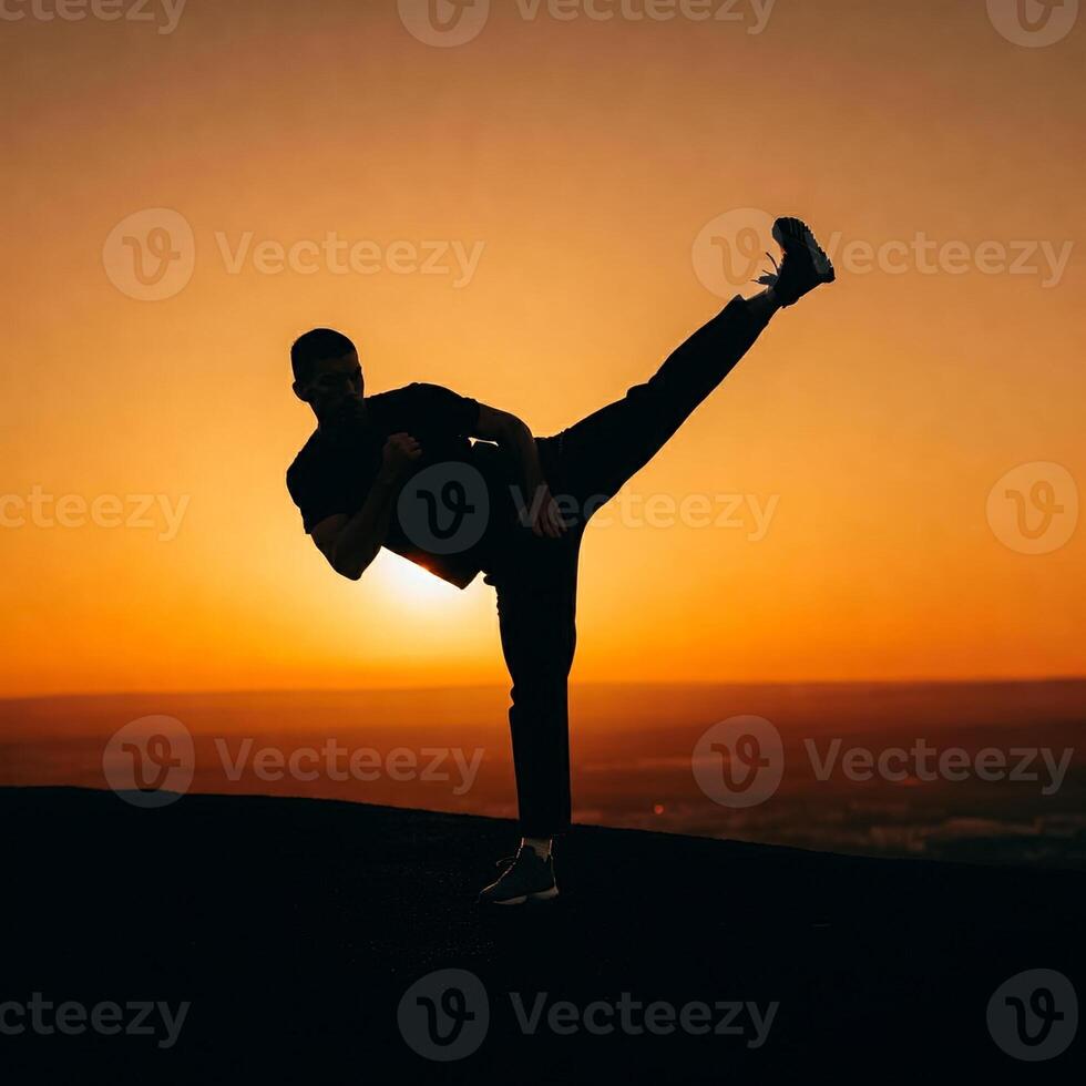 A man doing a kick at sunset photo