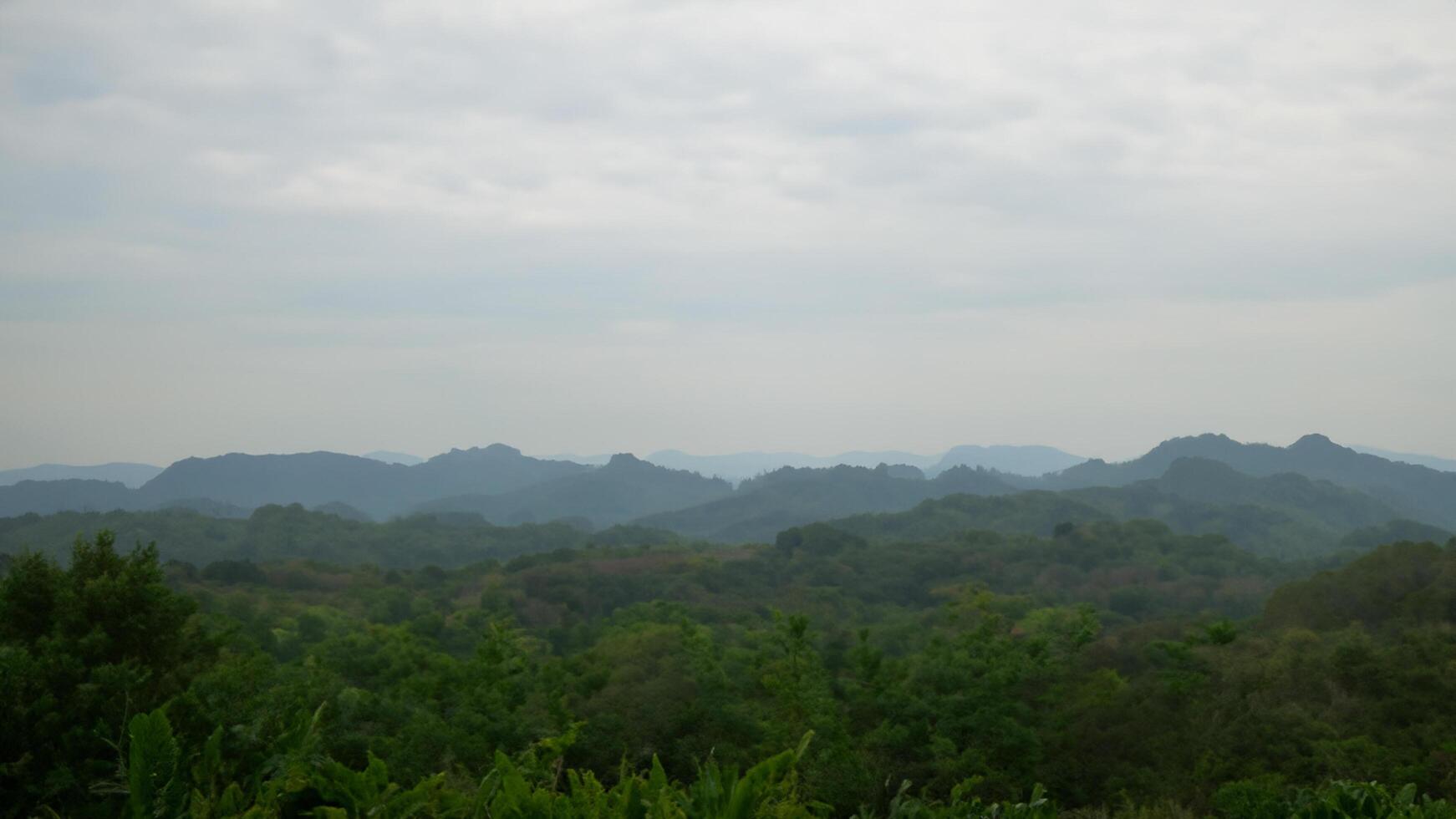 Misty mountain range landscape, distant hills, green forest, travel postcard photo