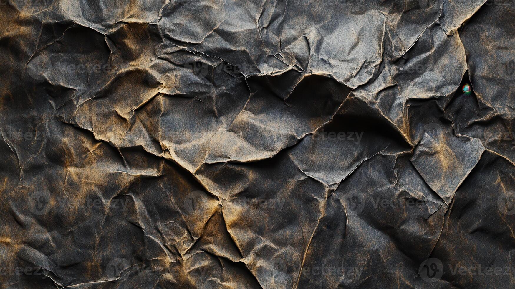 Crumpled dark paper texture, gold highlights, background blur, design element photo