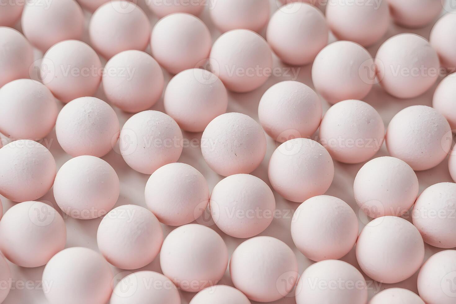 Close-up of pastel pink round candies or sweets arranged in rows. photo