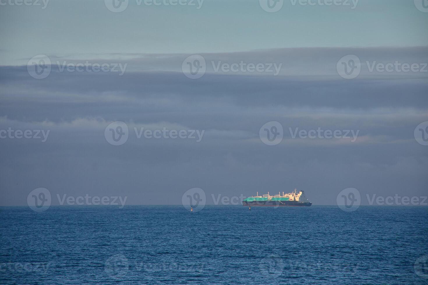 A solitary ship navigates the cantabrian sea off the coast of gijon photo