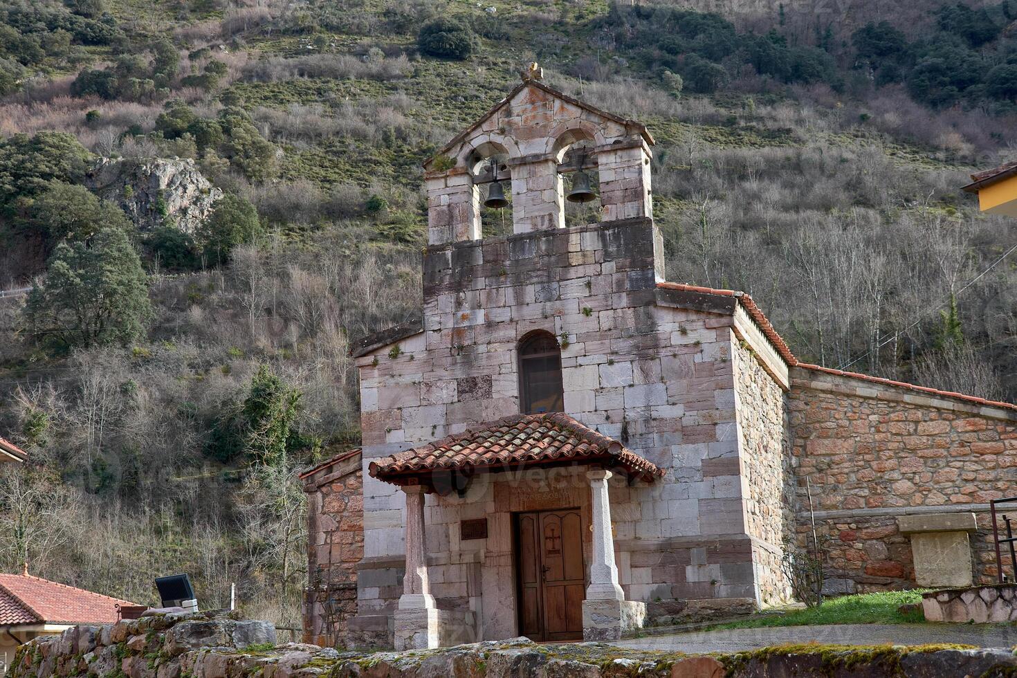 Beautiful old church of Pola de Somiedo with a scenic mountain backdrop in Asturias photo