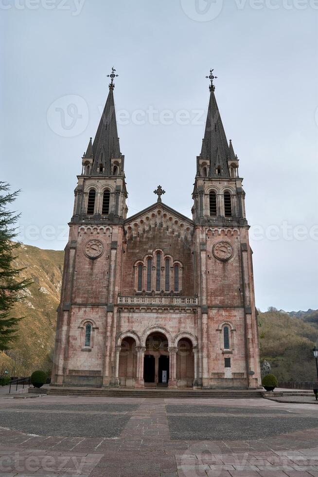 Stunning view of the Basilica of Santa Maria in Covadonga, surrounded by nature and mountains photo