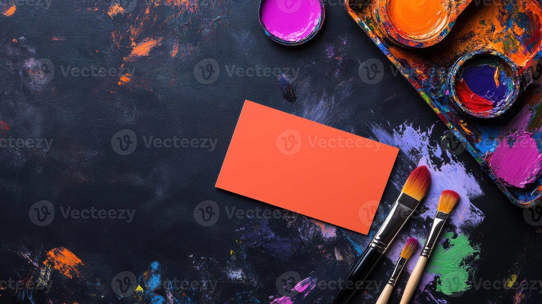 vibrant workspace with paint, brushes, and blank card for creativity photo