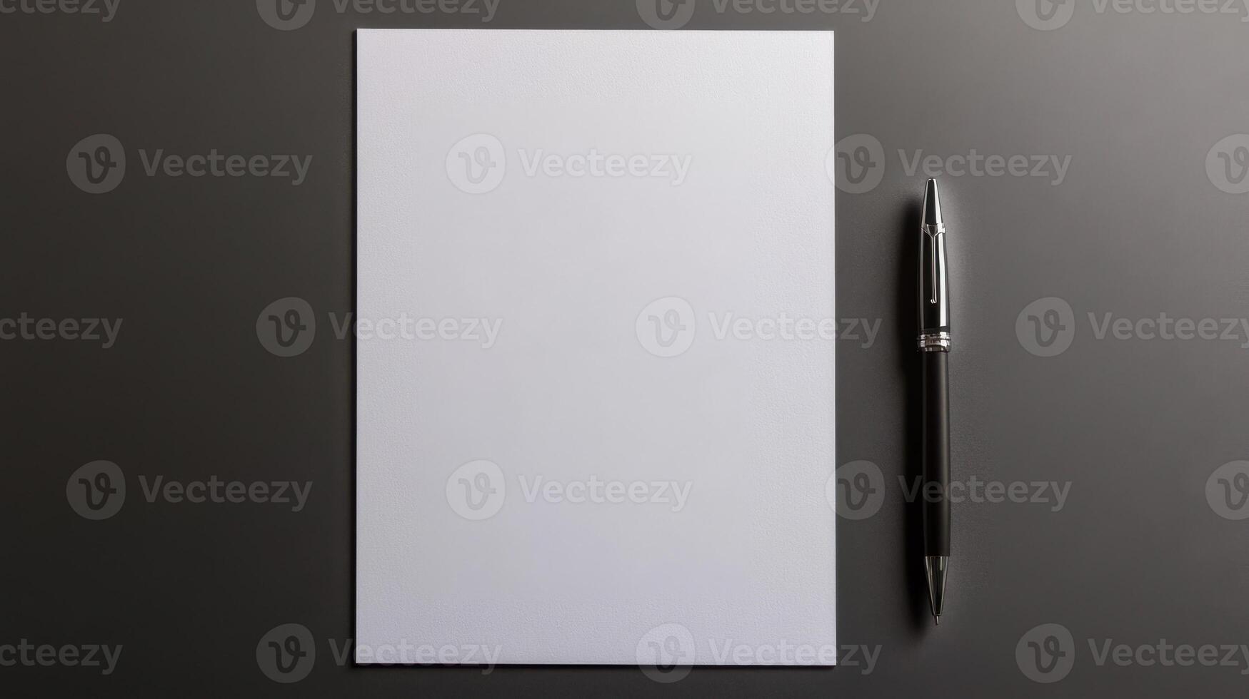 blank sheet of paper with pen beside it on dark surface, ready for notes photo