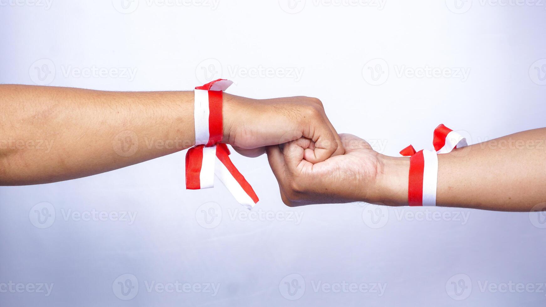 Two Hands Wearing Red and White Ribbons Holding Each Other on White Background photo