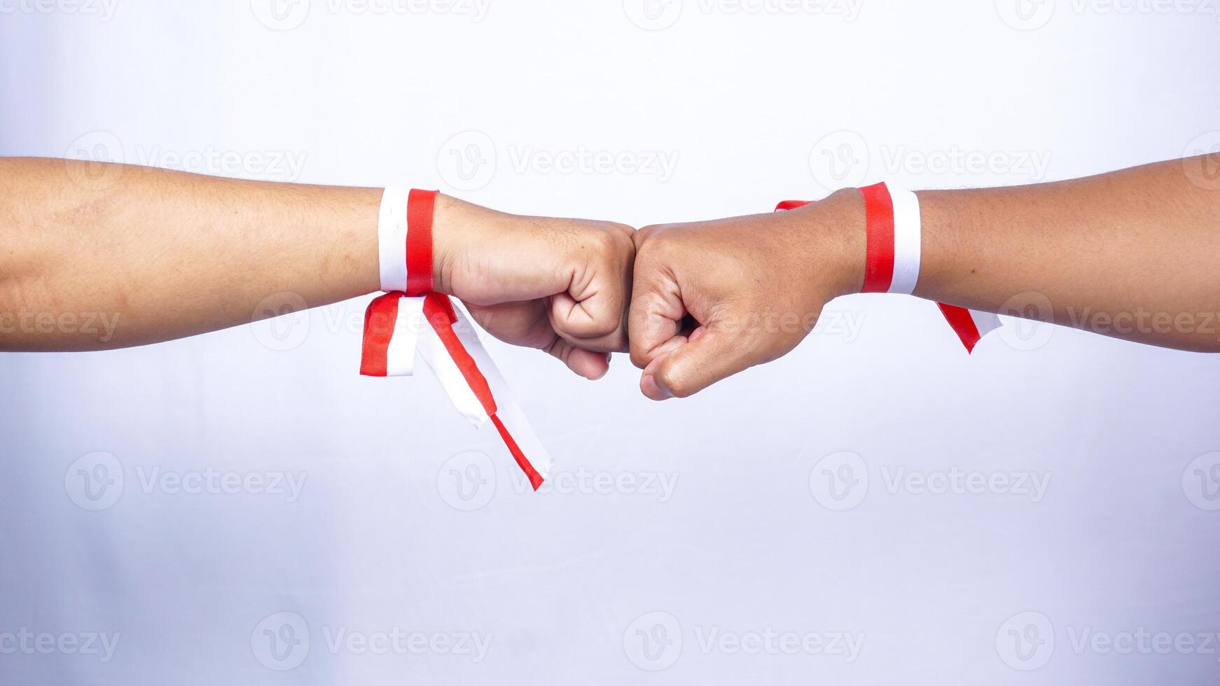 Hands Wearing Red and White Ribbons Doing Clenched High Five on White Background photo