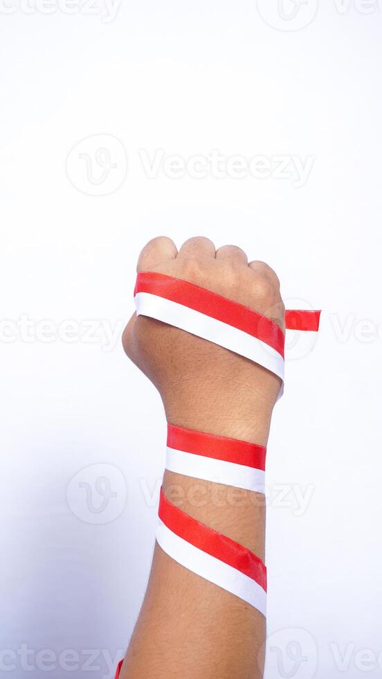 Man's Clenched Fist with Red and White Ribbons Wrapped Around The Hand on White Background photo