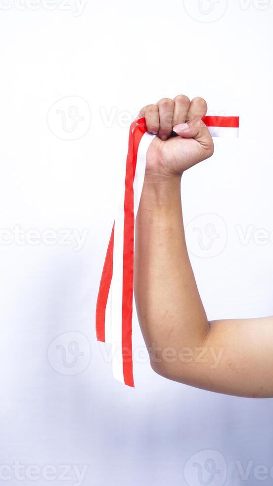 Hand Holding Red and White Ribbons with Clenched Fist on White Background photo