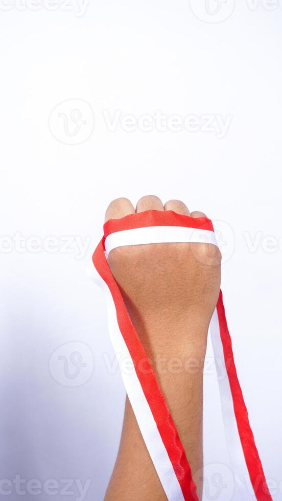Clenched Fist Holding Red and White Ribbons on White Background photo