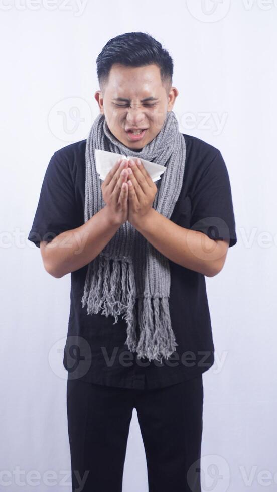Sick Asian Man Sneeze Into Tissue Paper on White Background photo