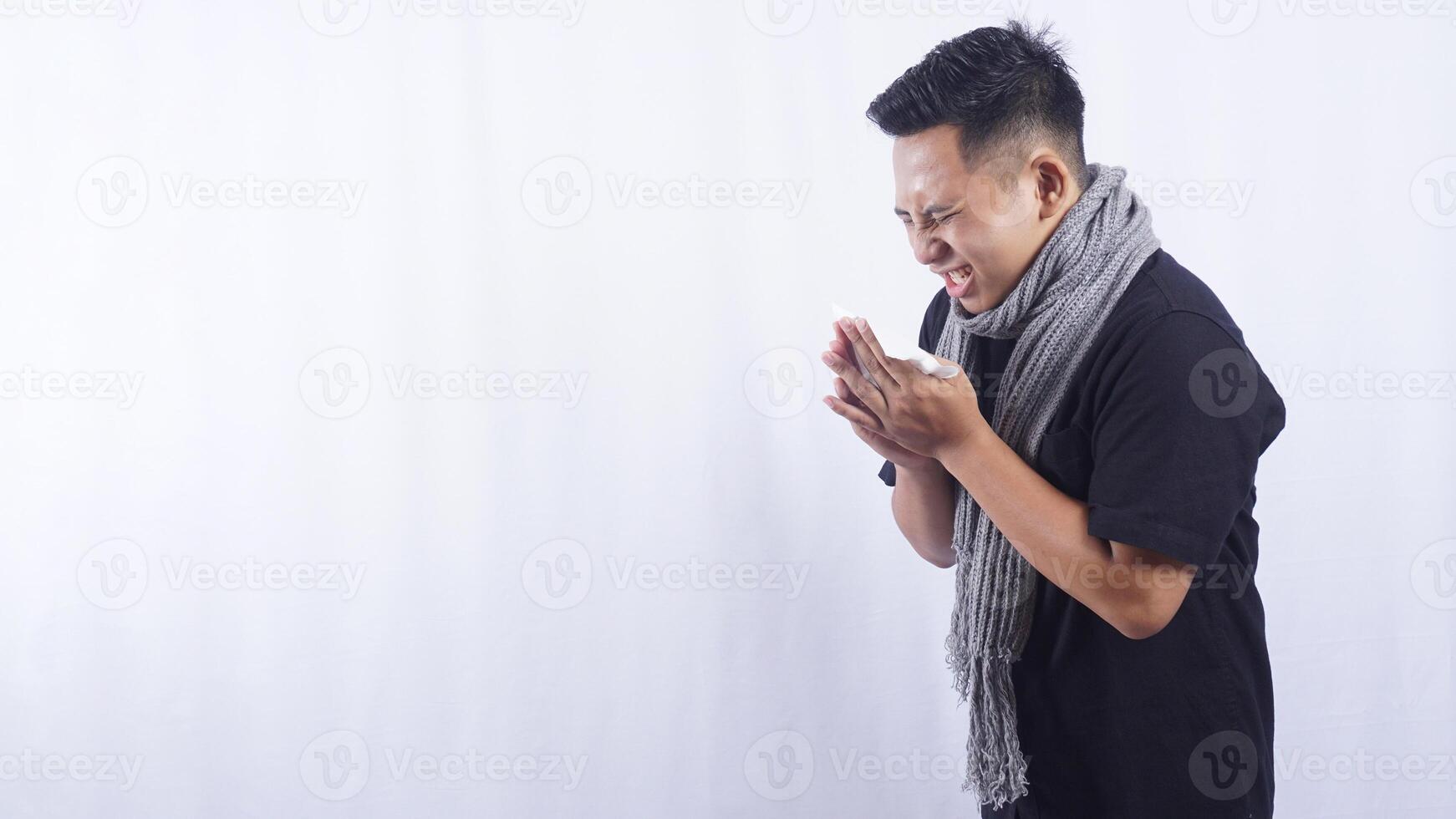 Side View of Unhealthy Asian Man Sneeze Into Tissue Paper on White Background photo