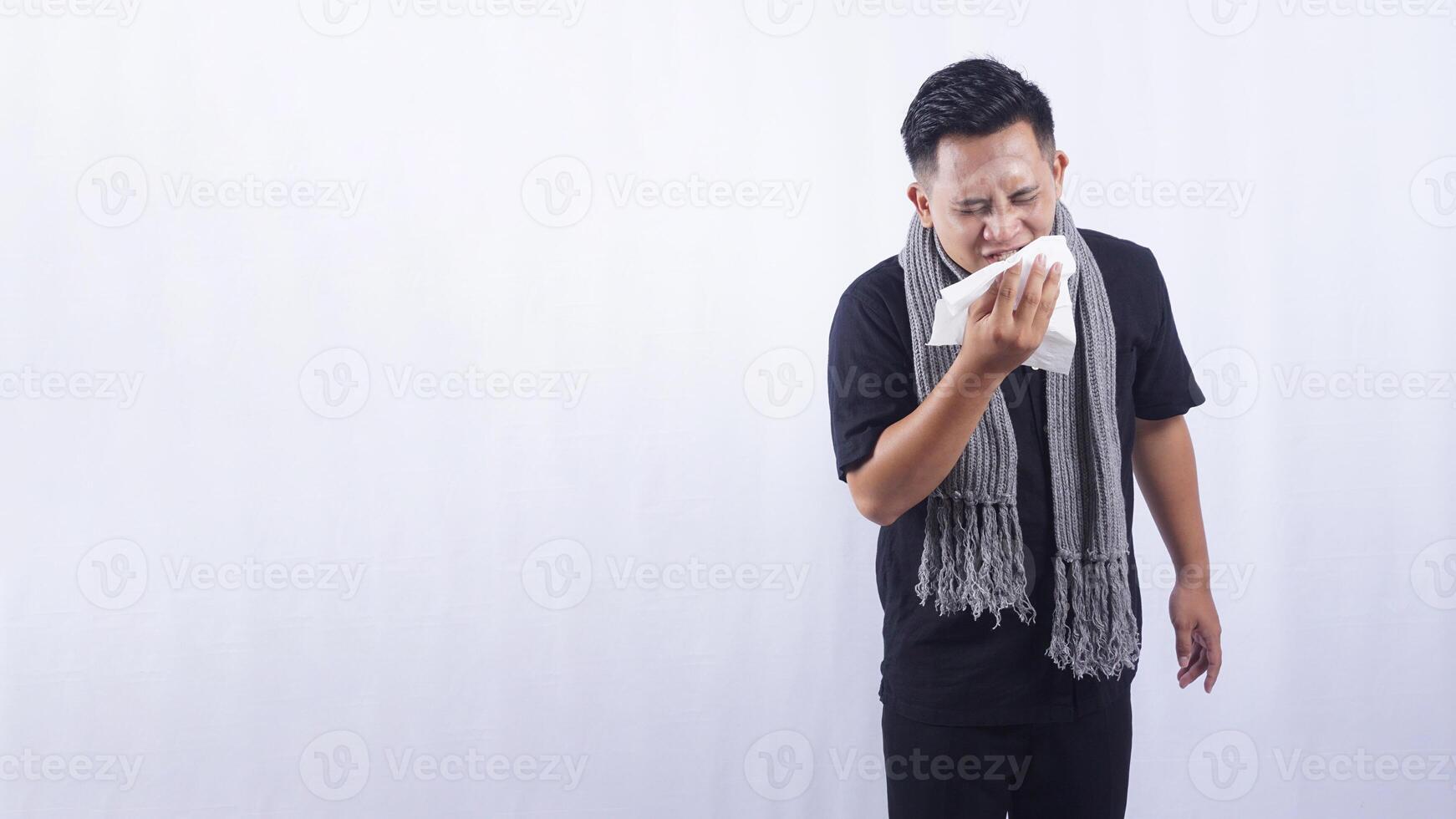 Asian Man Sneeze Into Tissue Paper Suffering from Flu on White Background photo