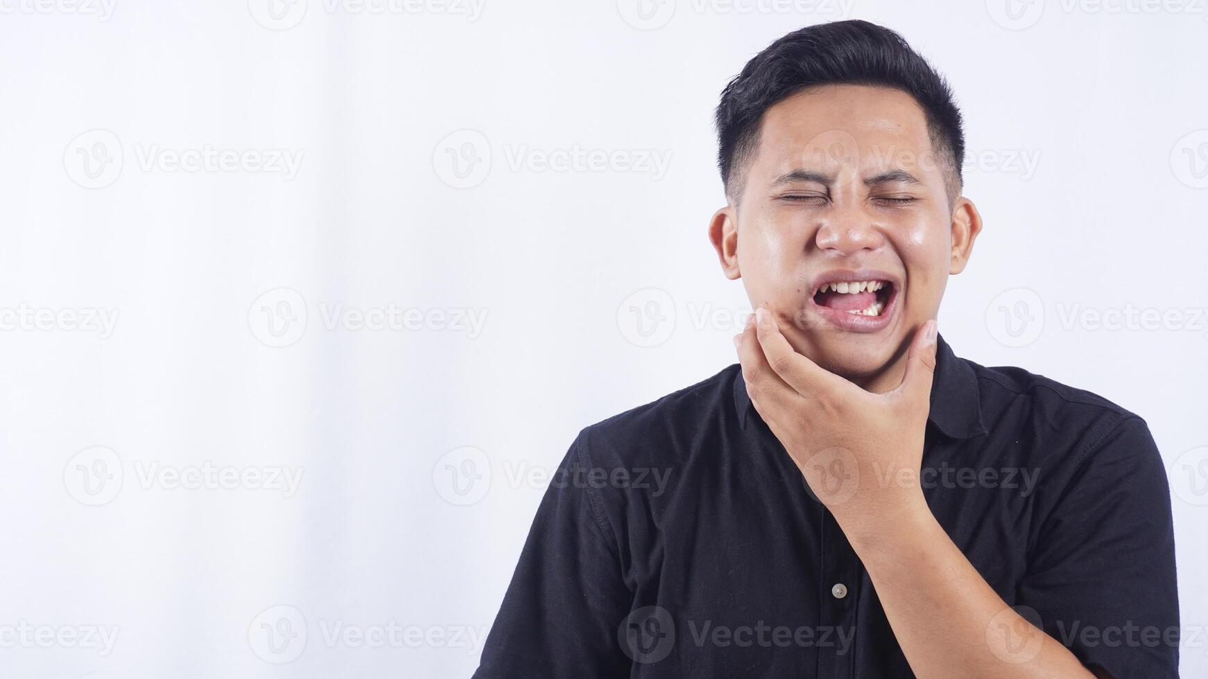 Upset Young Asian Man with Swollen Cheek Suffering from Toothache on White Background photo