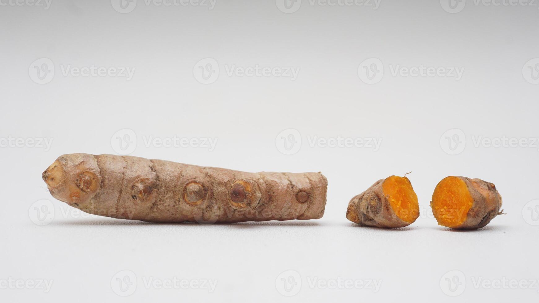 Pieces of Turmeric Spice on White Background photo
