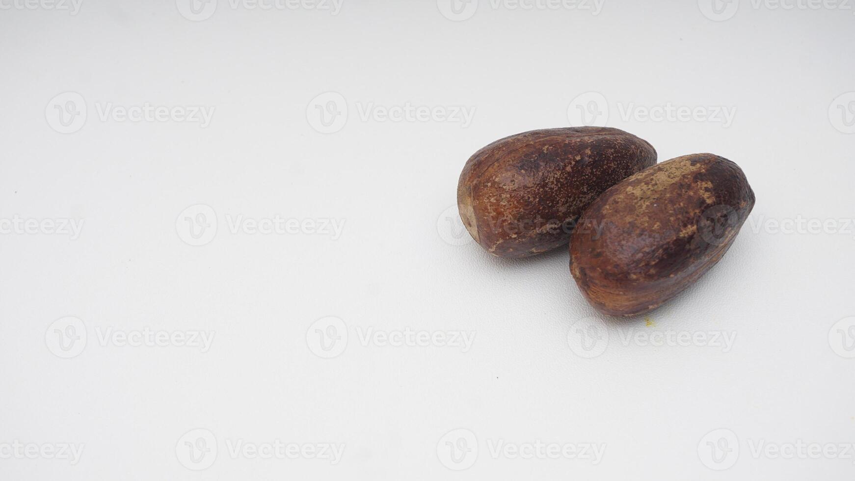 A Pair of Nutmegs Spice on White Background photo