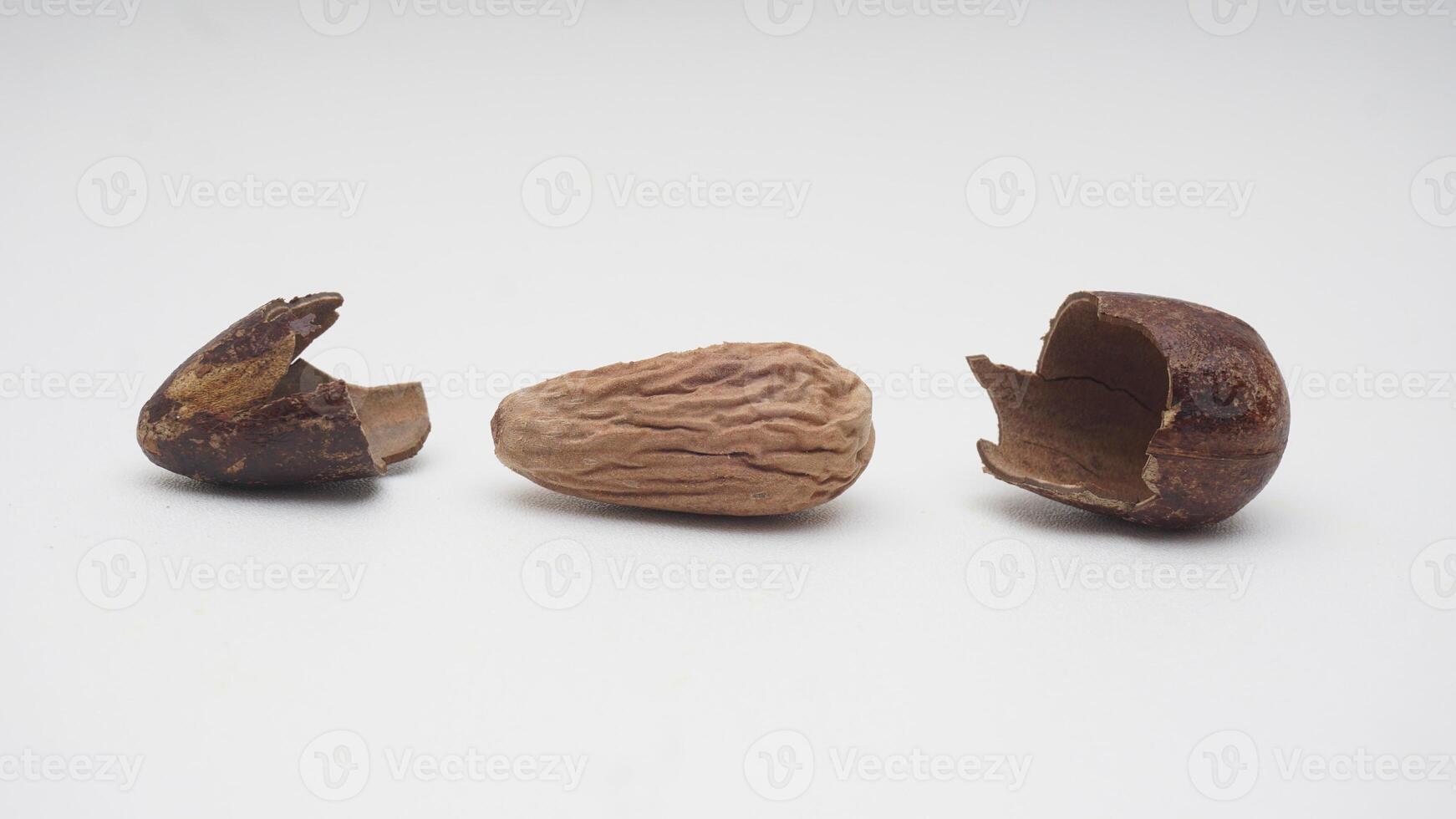 Nutmeg Spice Seed with Its Broken Skin on White Background photo