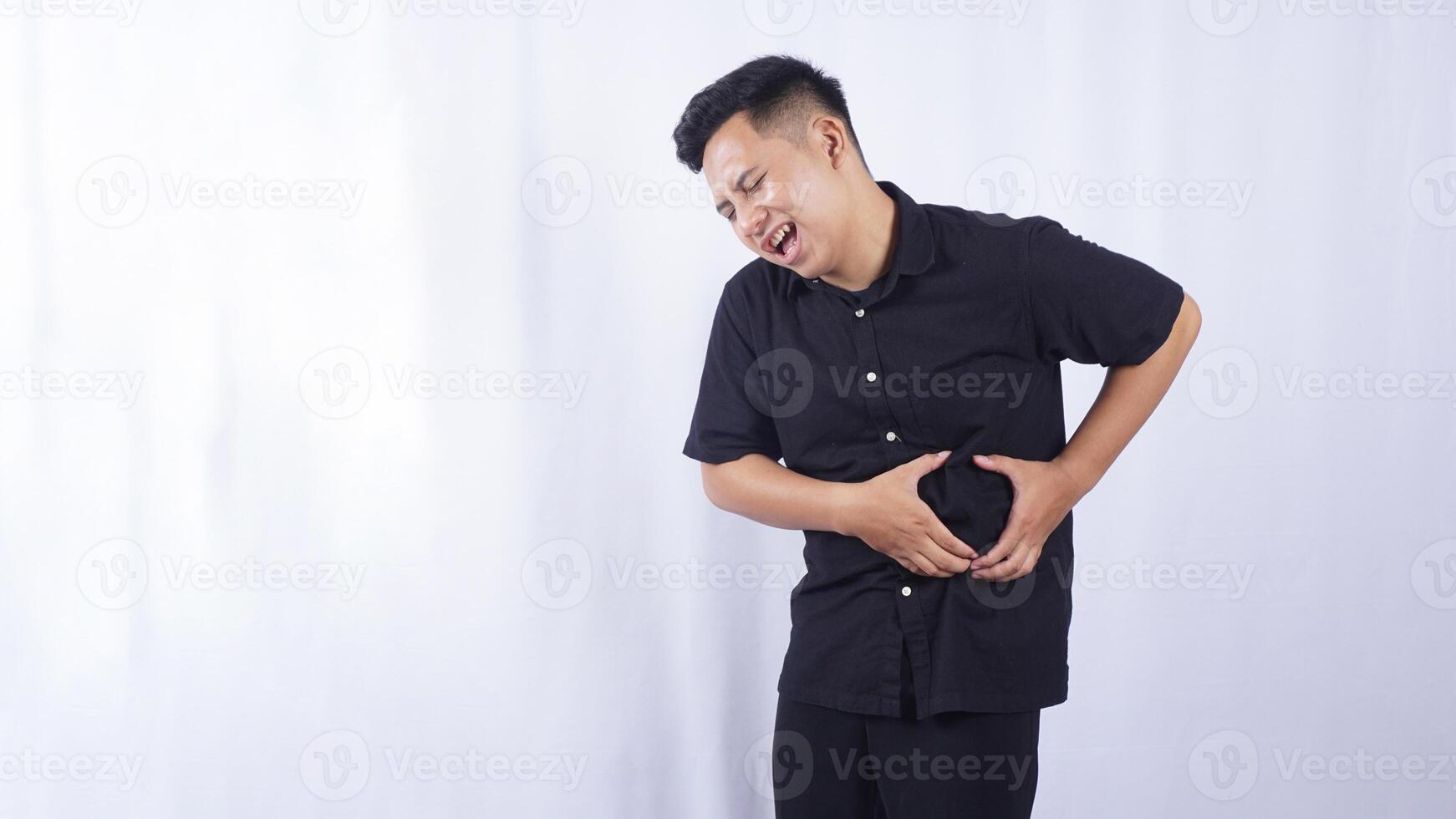 Unhappy Asian Man with Stomach Pain on White Background photo