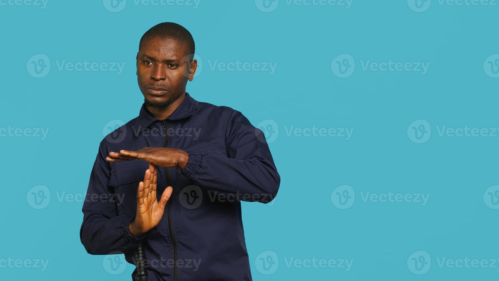 Security guard standing in fighting stance, prepared to deal with people entering restricted area. Portrait of bodyguard holding defensive pose, ready to throw punches, studio background, camera A photo