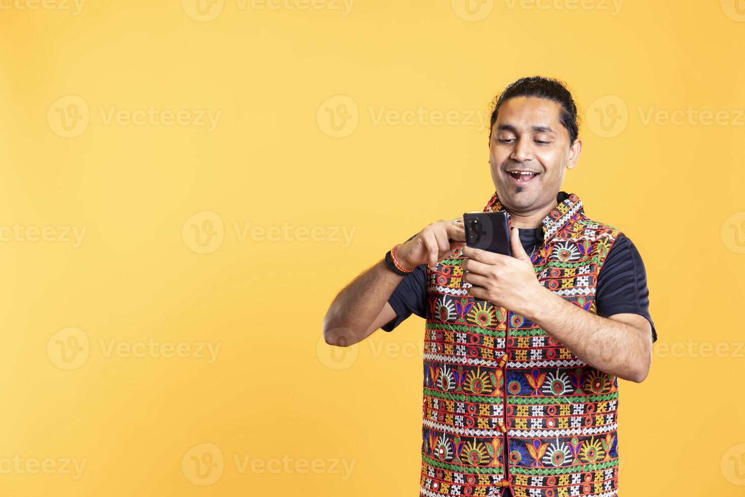 Man adding payment method on phone website, delighted to take advantage of promotions, studio background. Person thrilled to do internet shopping, typing credit card data on smartphone photo