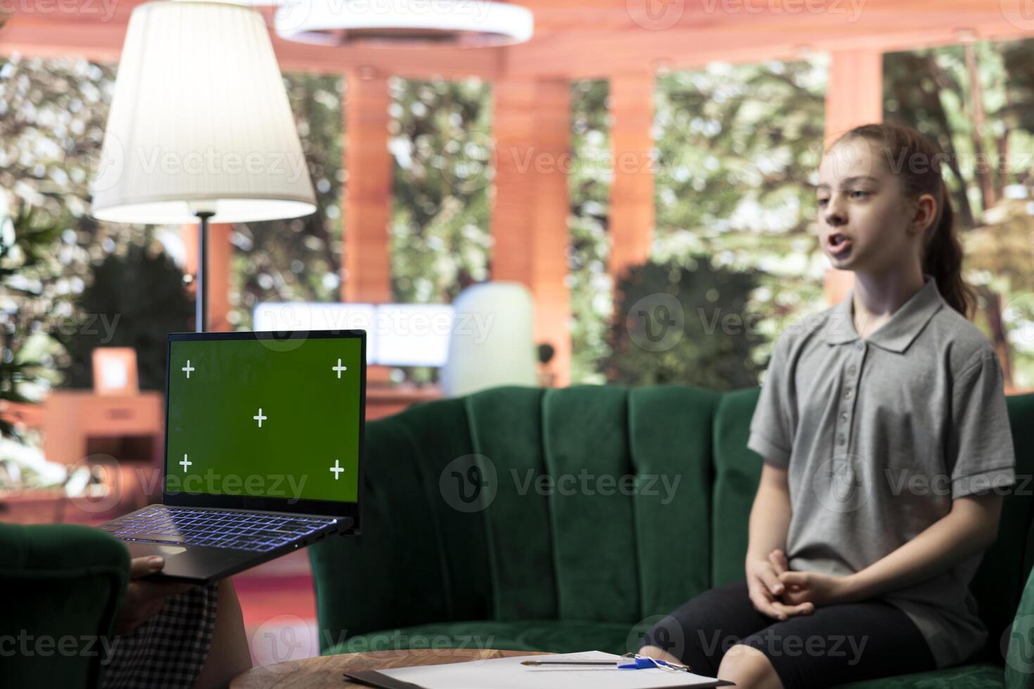 Therapist uses green screen display in a counseling session with an adolescent dealing with low confidence. Psychotherapist supports her in building resilience and self esteem. photo
