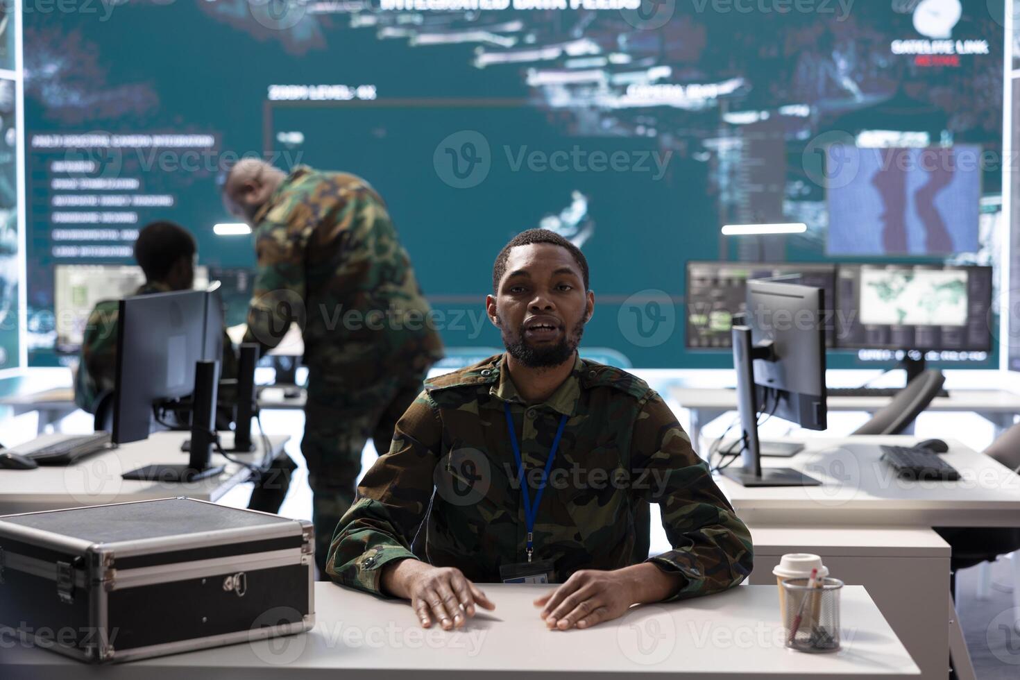 Army soldier in a high tech monitoring room conducts a videocall, leveraging secure communication channels and real time intelligence for effective mission coordination. National defense activity. photo
