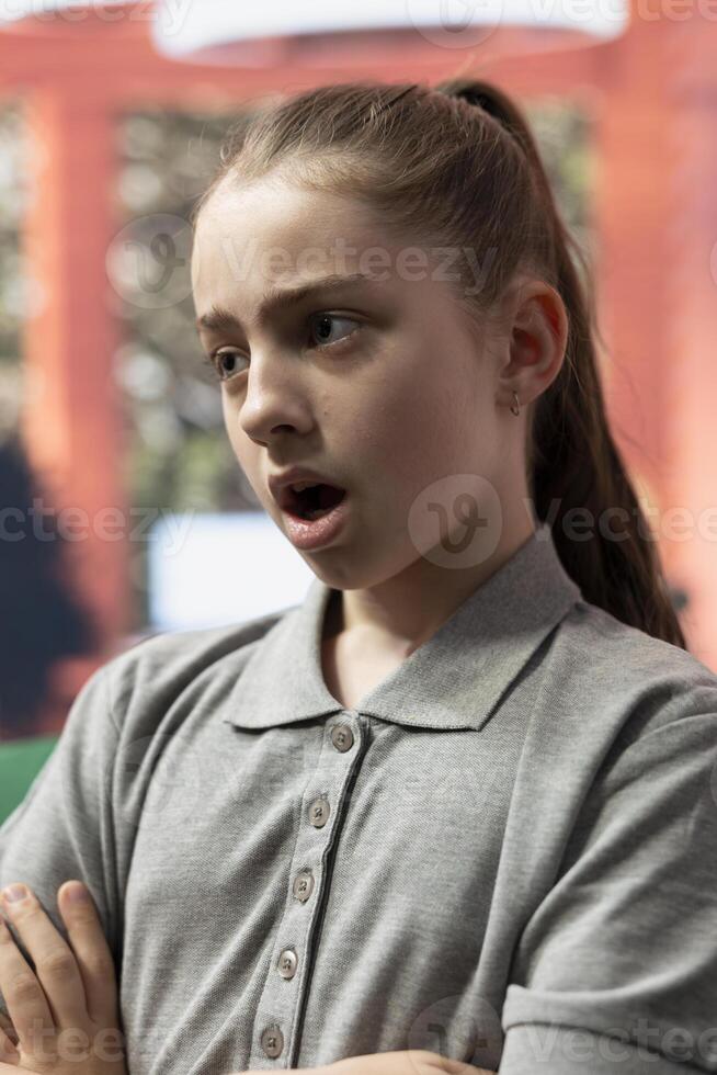 Angry teenager revealing emotional issues and bullying related stress, challenges the therapist in a rebellious confrontation. Counseling focuses on managing aggression and rudeness. Close up. photo