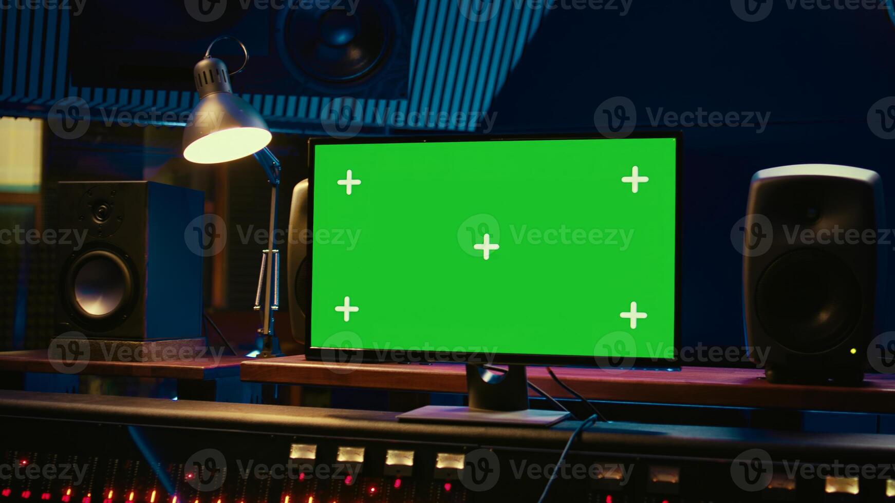 Control room with greenscreen running on computer next to buttons and sliders, multiple controls and switchers on panel board mixing console. Empty professional studio with stereo gear. Camera B. photo