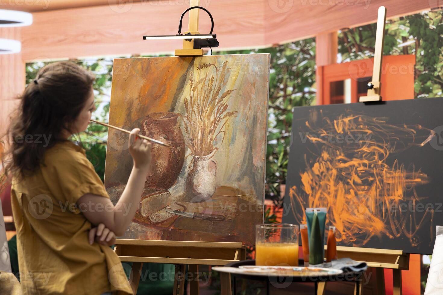 Painter spends quality time in her studio creating a masterpiece, perfecting her latest fine art piece. Woman using multicolored pigments and painting techniques to highlight skill and dedication. photo