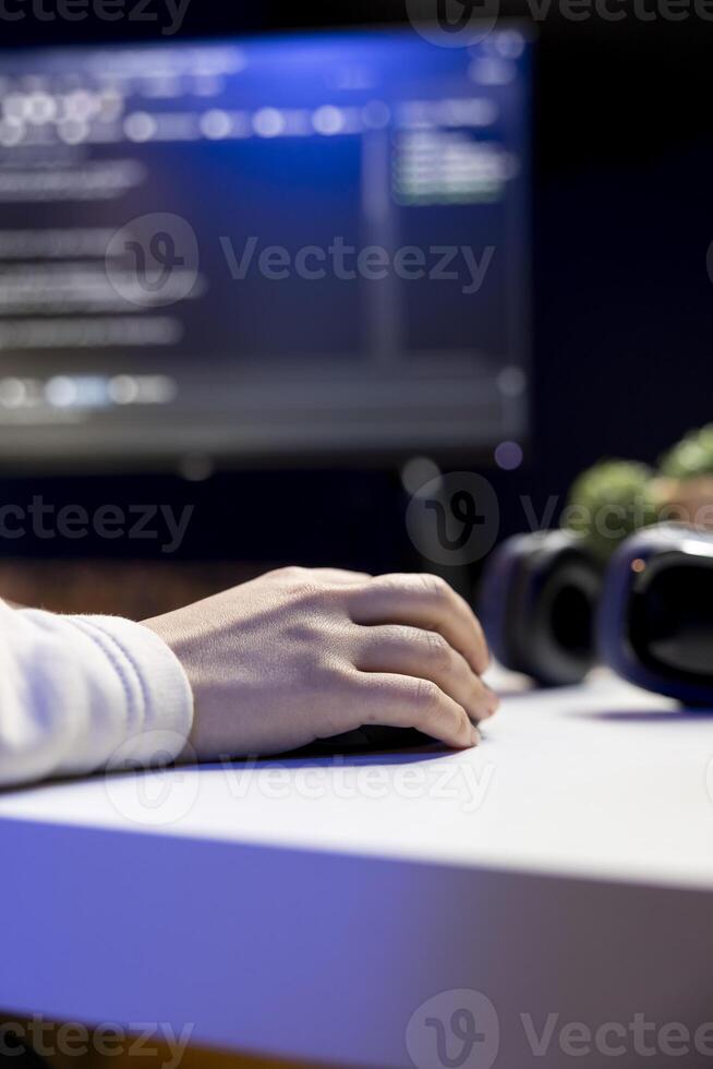 Teleworking IT admin working from RGB lit home, testing and deploying programs and systems. Close up of software technician checking code displayed on computer screens in apartment photo