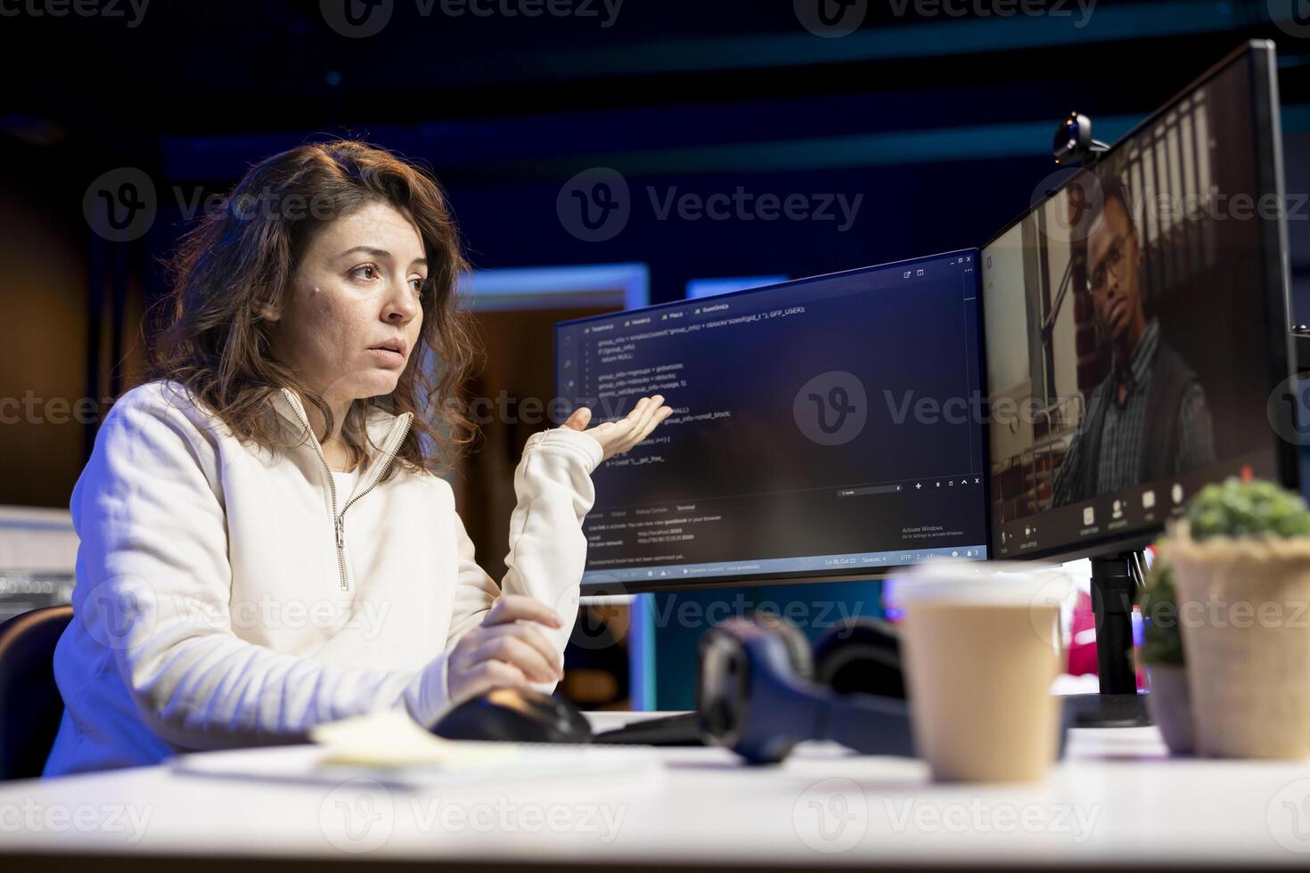 Developer doing software debugging helped by coworker in videocall, checking errors in lines of code. Woman working from home fixing coding mistakes, assisted by colleague in teleconference photo