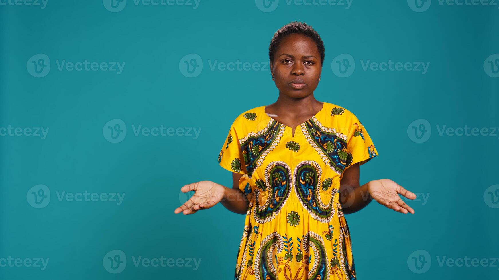 Uncertain woman acting confused and raising shoulders in studio, being clueless and making an i dont know sign. Indecisive unsure person feels doubtful, something ambiguous. Camera B. photo