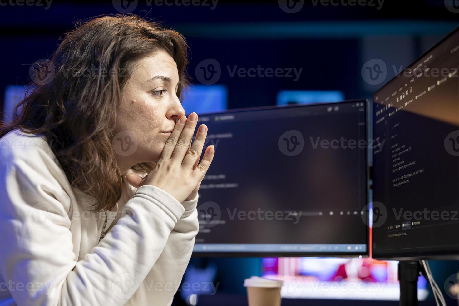 Pensive woman developing software in Java programming language using desktop PC, examining. Contemplative programmer in apartment thinking how to solve coding issues on computer photo