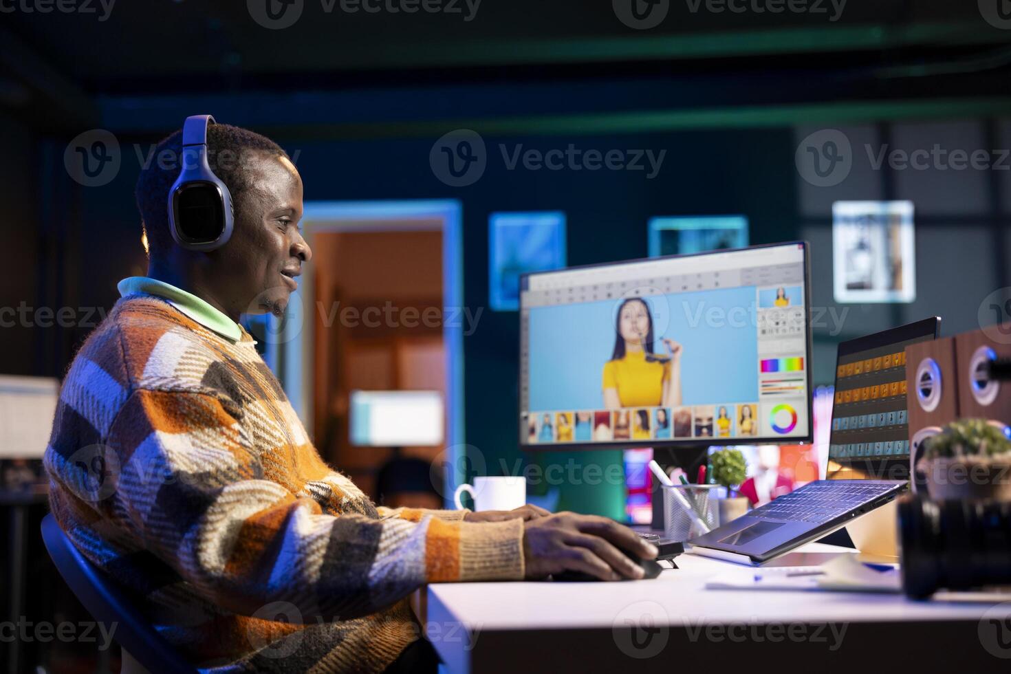 Black man photo editor in a well organized workspace editing images on dual monitors using advanced software tools, displaying creativity and professional dedication. Computer setup.