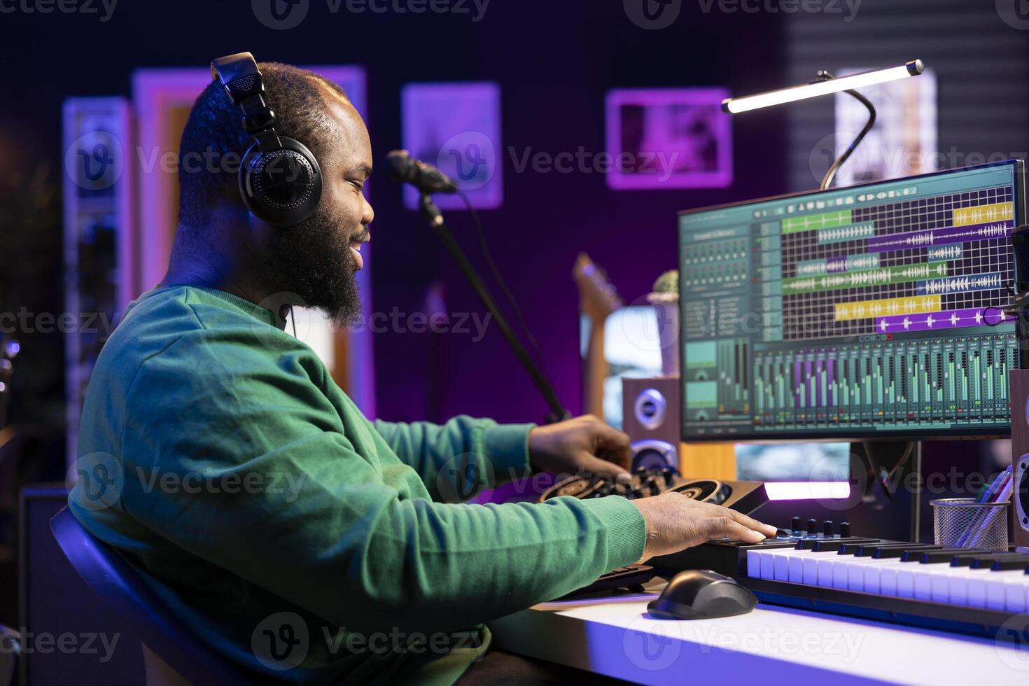 Audio technician editing tunes on mixing console to adjust volume levels, twisting pre amp knobs in home studio. Composer producing new music with professional stereo equipment. photo