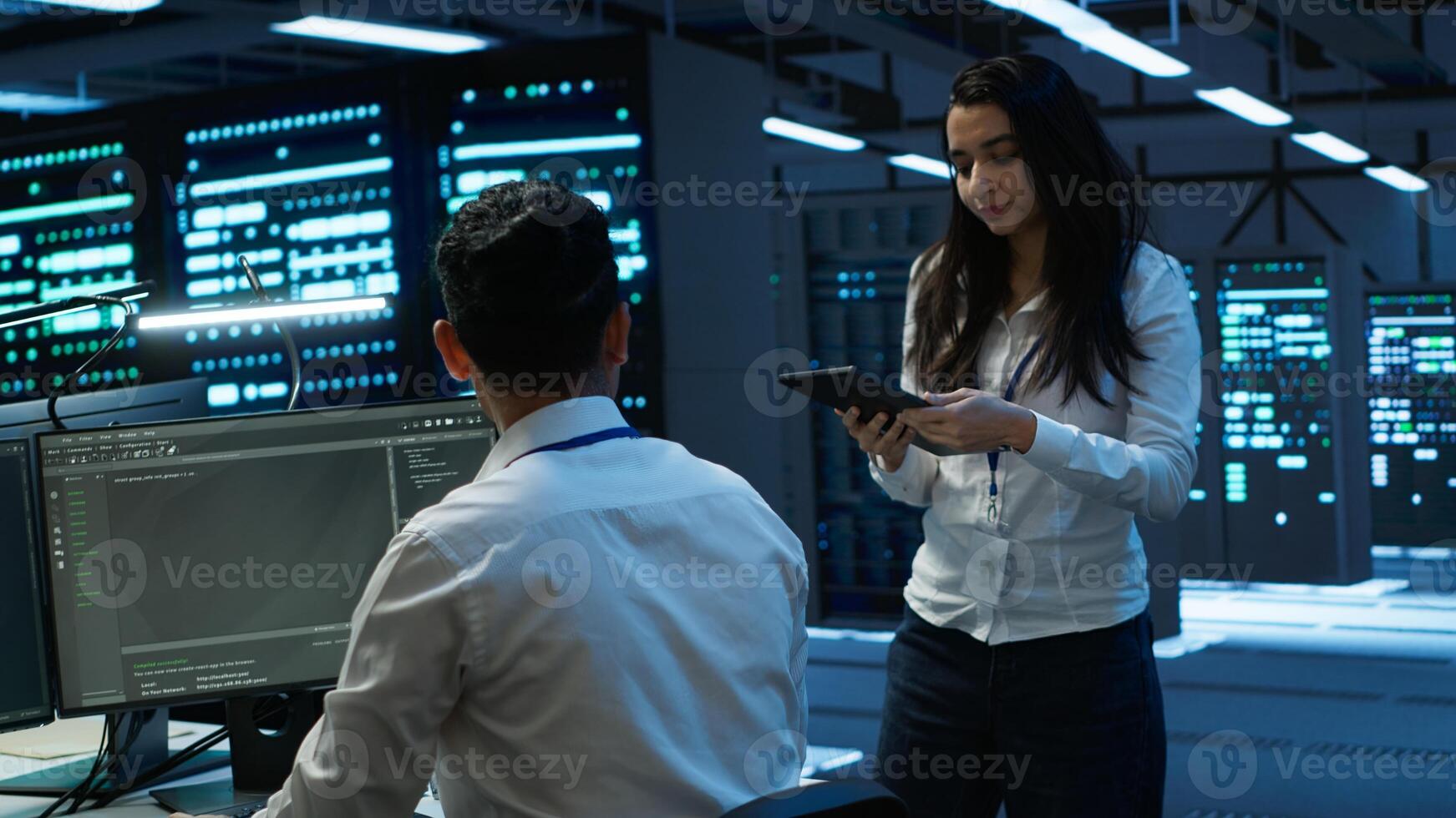 Coworkers in high tech data center monitoring security threats, implementing cybersecurity measures. IT staff members ensuring compliance with server room workspace regulations photo