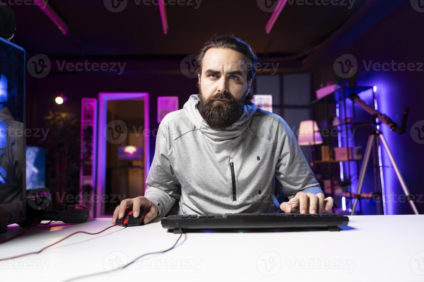 Content creator sitting on gaming chair filming tutorial for audience on how to defeat enemies in multiplayer game. Pro player playing videogame, teaching viewers esports strategies photo