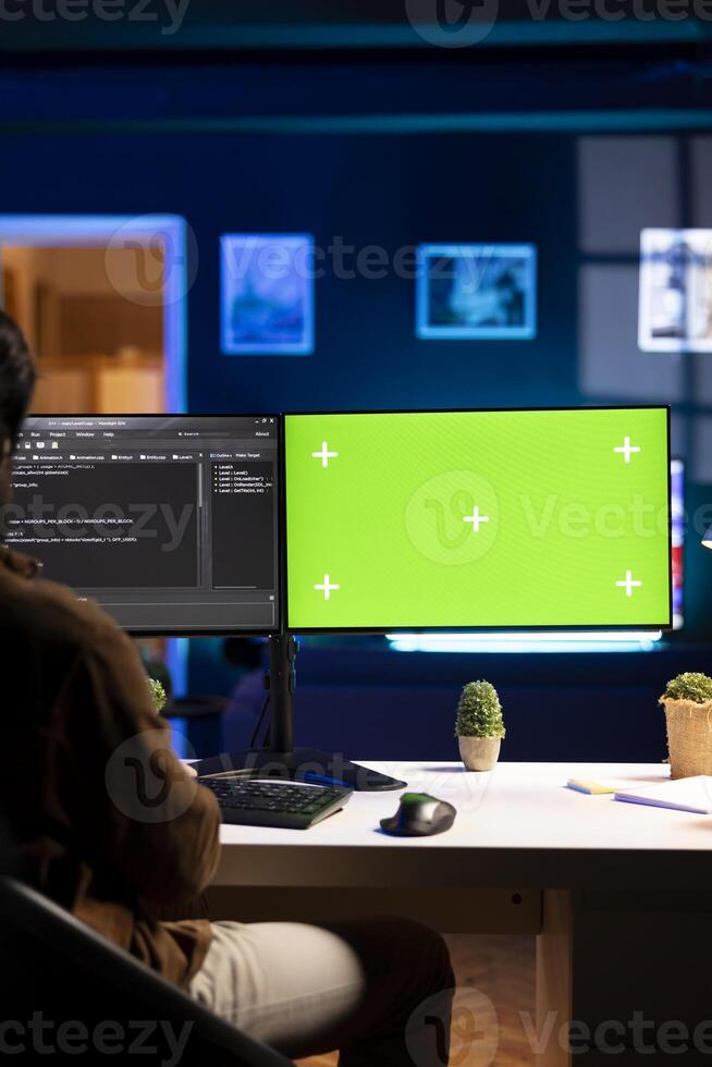 Programmer using green screen computer to secure company servers from virus attacks. IT remote employee writing code, building firewalls protecting data using mockup PC monitor photo