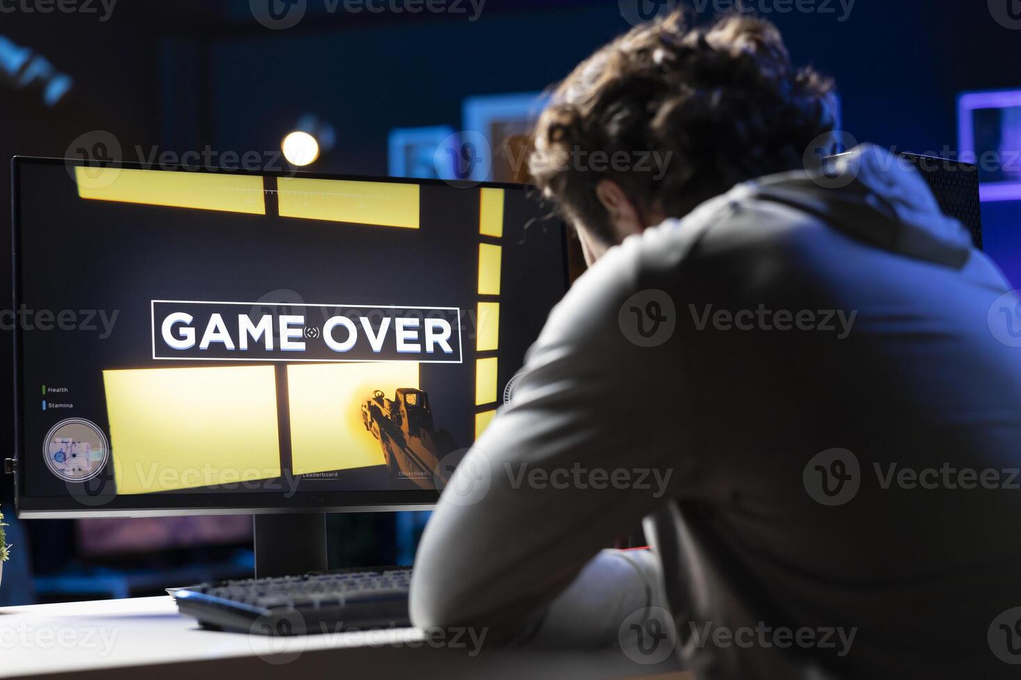 Gamer struggling to defeat opponents while playing esports tournament, unhappy with his performance. Upset player losing while competing in multiplayer videogame, throwing headphones in frustration photo