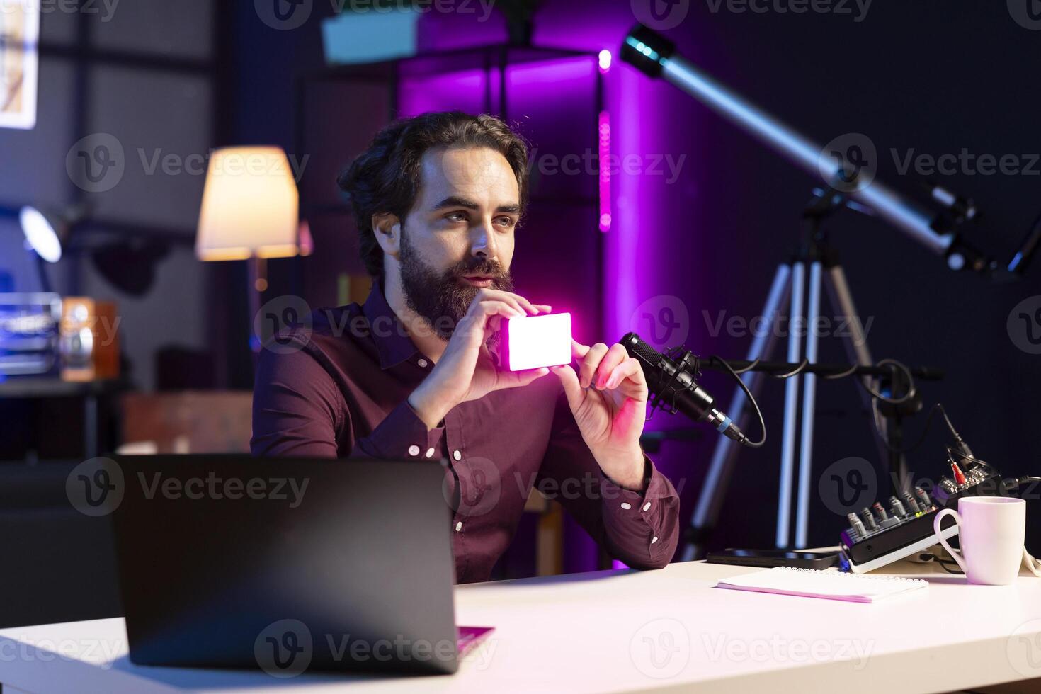 Reviewer discussing with viewers about mini led lights during live broadcast on internet. Influencer chatting with fans during stream, filming RGB lighting device in studio photo