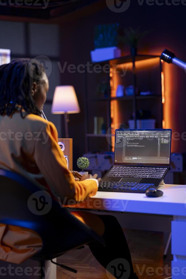 Technician in home office typing code on notebook device, developing software programs, entering commands. Skillful gen Z teenager at home fixing errors in application, implementing new features photo
