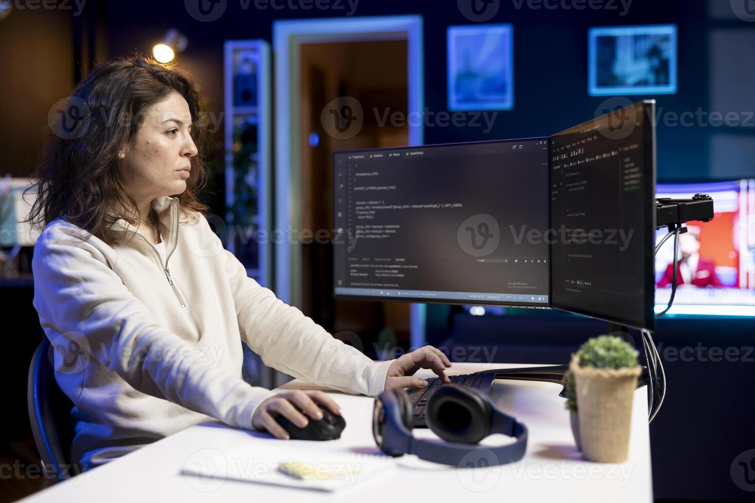 Computer scientist doing software debugging on PC at home, checking broken lines of code displayed on monitors. Skilled IT expert in apartment fixing coding problems, typing on keyboard photo