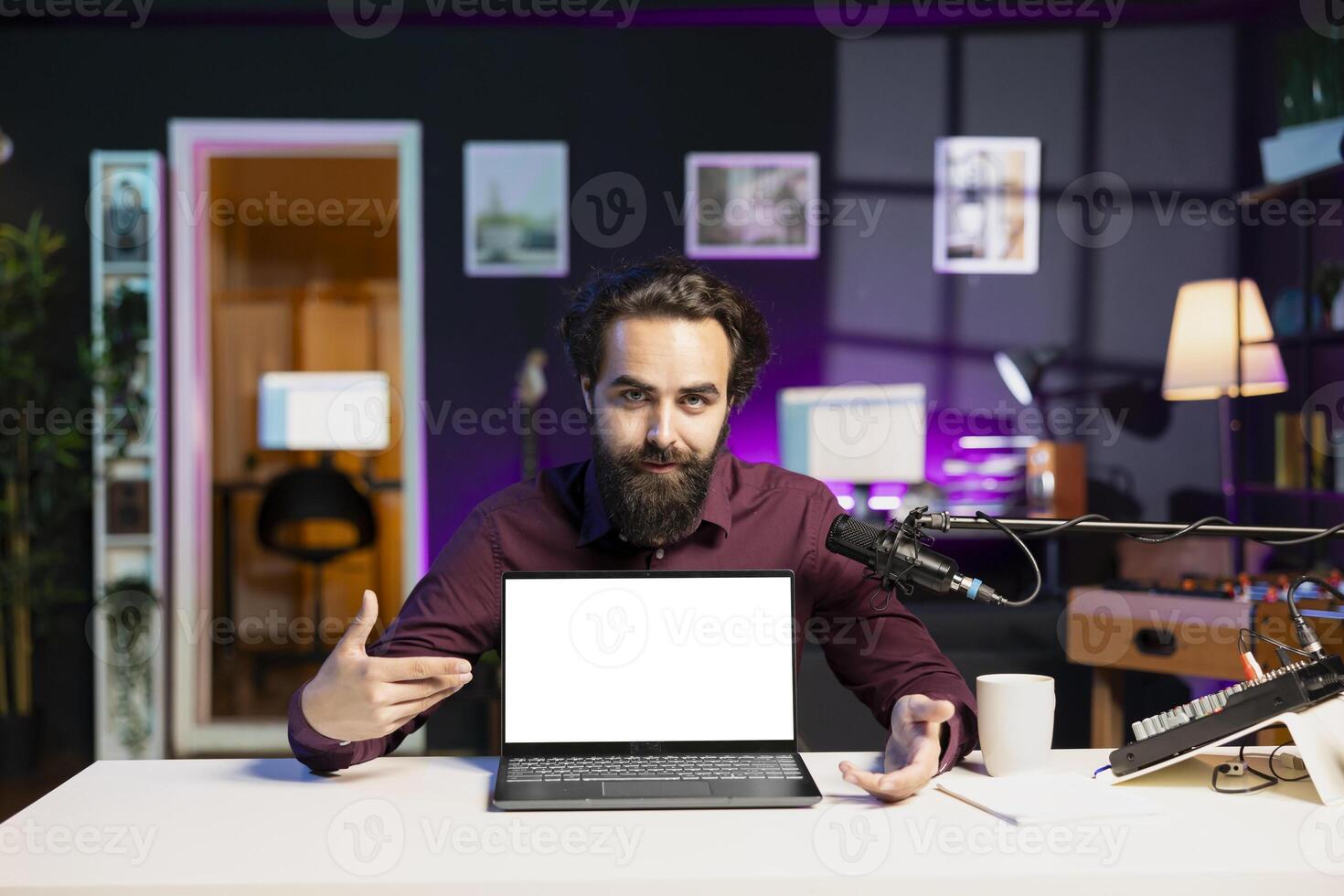 Portrait of entertainer in studio reviewing mockup laptop received from sponsor, doing influencer marketing. Tech guru advertising isolated screen notebook during sponsorship promotion photo
