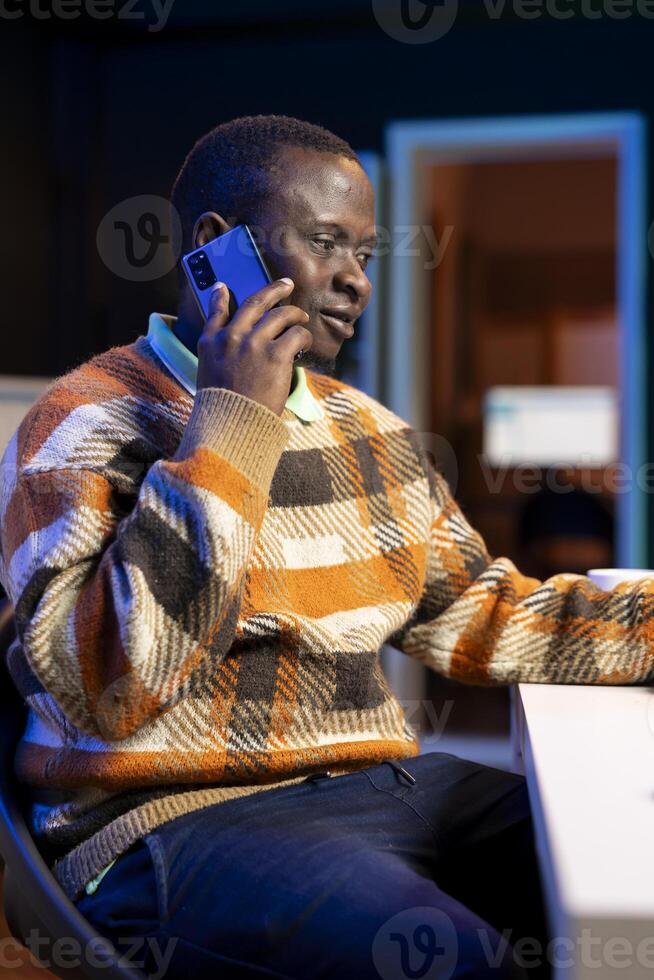On a phone call from home, economist seeking to secure new financial support from investors. African american financial advisor operating remotely to increase earnings and lower expenses. photo