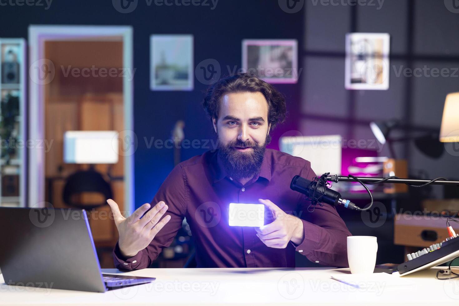 Portrait of happy reviewer discussing with viewers about mini led lights during live broadcast on internet. Cheerful influencer talking with fans during stream, filming RGB lighting device in studio photo
