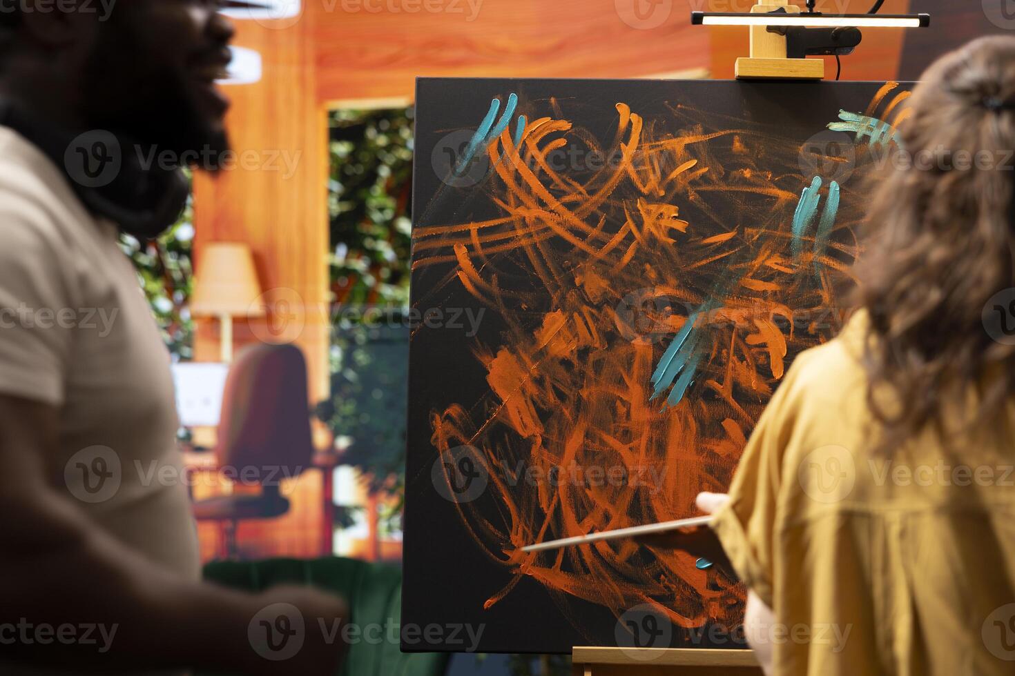 Team of artists in a gallery atelier working on a new art piece, using the finger painting technique for an abstract creation. Blending acrylic paints with precision to create a contemporary design. photo