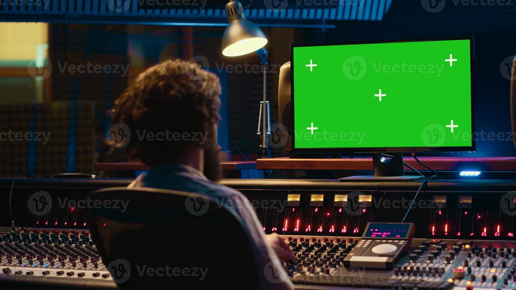 Tracking engineer watching tutorials online to learn mixing and mastering techniques, greenscreen display on pc and processing sounds. Artist technician operates control room switchers. Camera A. photo