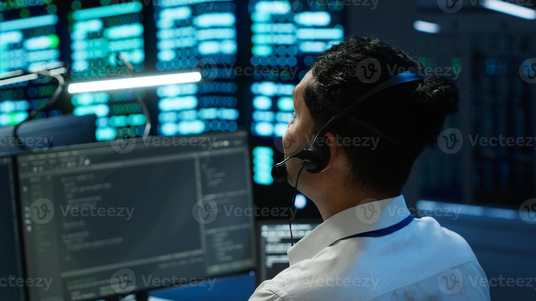 Data center computer scientist wearing mic headset, doing installation of networking equipment. Server hub IT professional talking in microphone with system administrators, camera A photo
