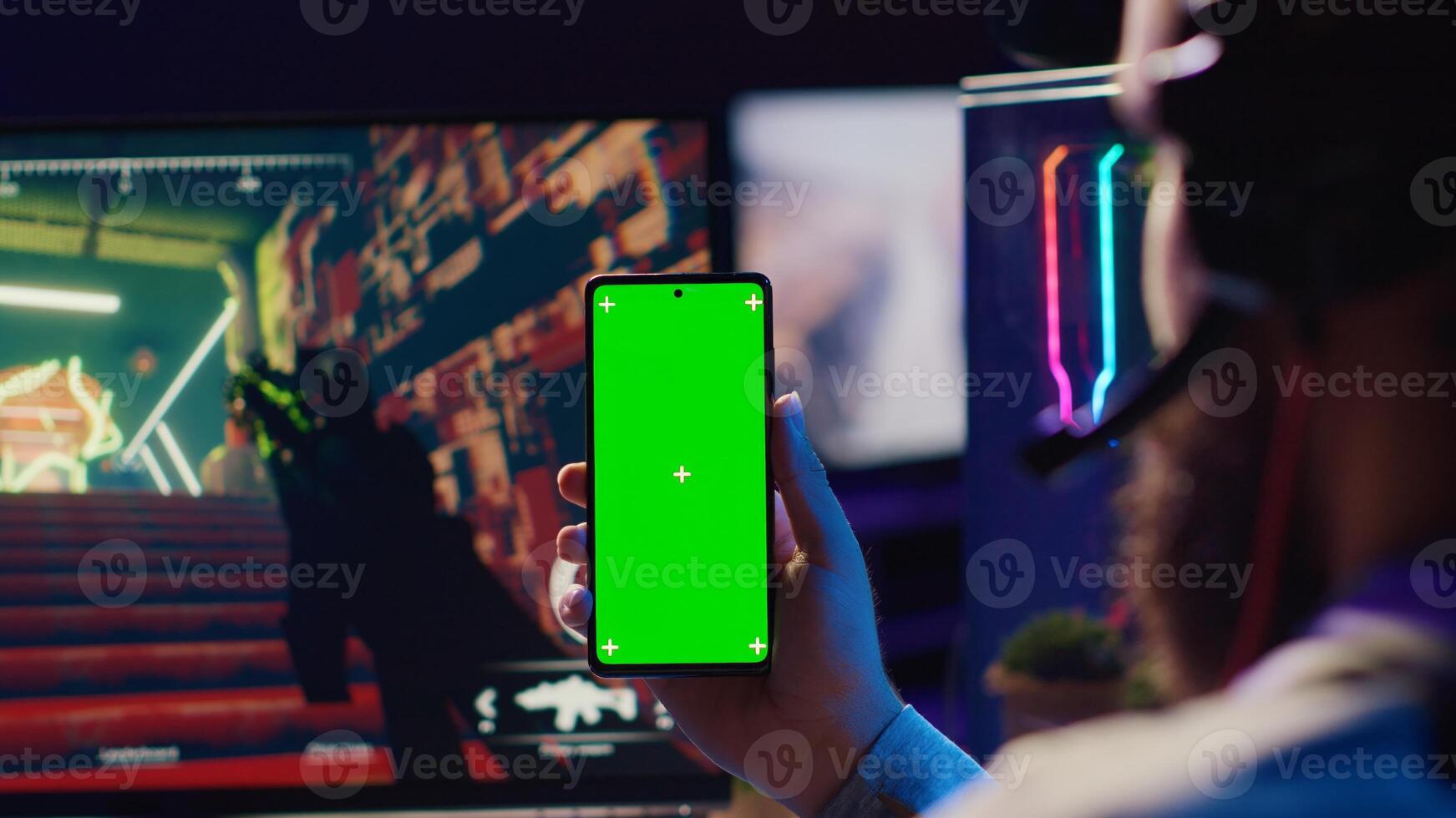 Man watching favorite content creator on green screen smartphone showing tips for game he is currently playing, close up. Player looking online for inspiration on chroma key phone, stuck on mission photo
