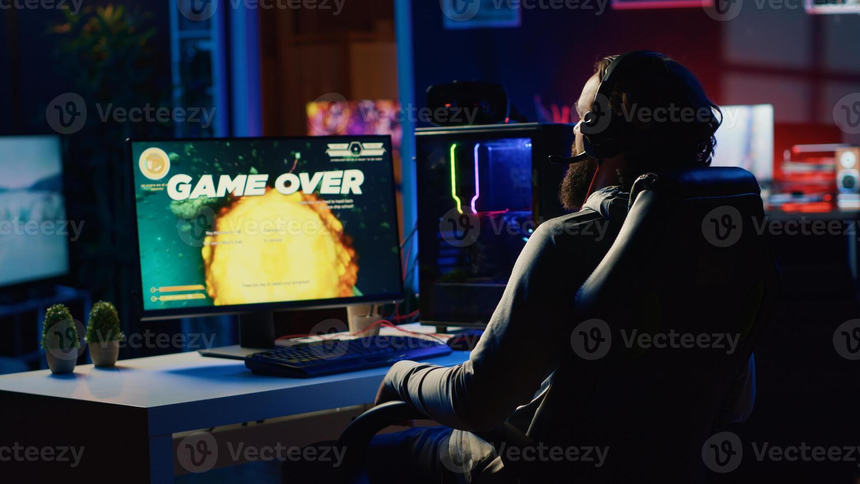 Upset gamer hitting desk in frustration after receiving game over screen, getting his spaceship destroyed in flying game. Sad player feeling disappointed after losing science fiction videogame photo